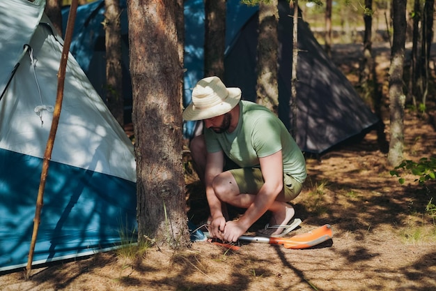 Blanke man met een hoed die een tent opzet Familie camping concept