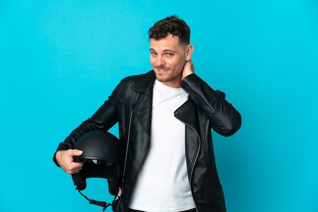 Blanke man met een motorhelm geïsoleerd op blauwe muur lachen