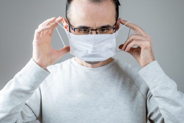 Blanke man met een wit medisch masker voor bescherming tegen besmettelijke ziekte, coronavirus