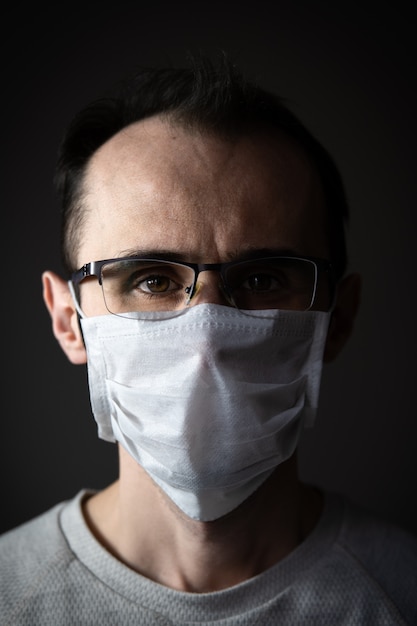 Blanke man met een wit medisch masker voor bescherming tegen coronavirus