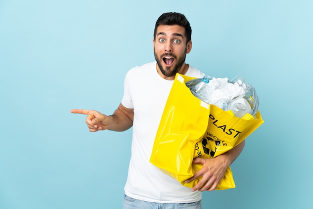 blanke man met een zak vol plastic flessen om te recyclen