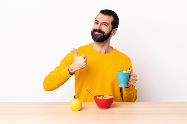 Blanke man ontbijten in een tabel met een duim omhoog gebaar