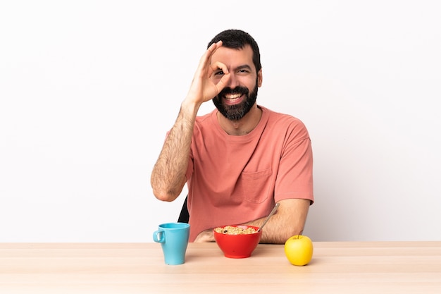 Blanke man ontbijten in een tafel met ok teken met vingers