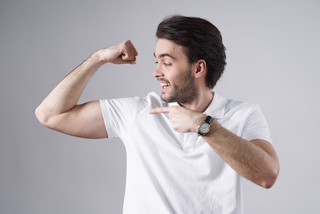 Blanke man poseren met biceps geïsoleerd op een witte achtergrond.