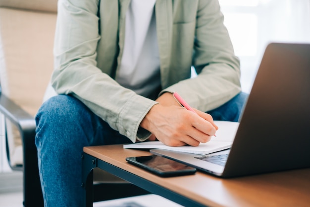 Blanke man student, studeren met laptop in de verte voorbereiden op proefexamen schrijven essay huiswerk thuis, verre onderwijs concept.