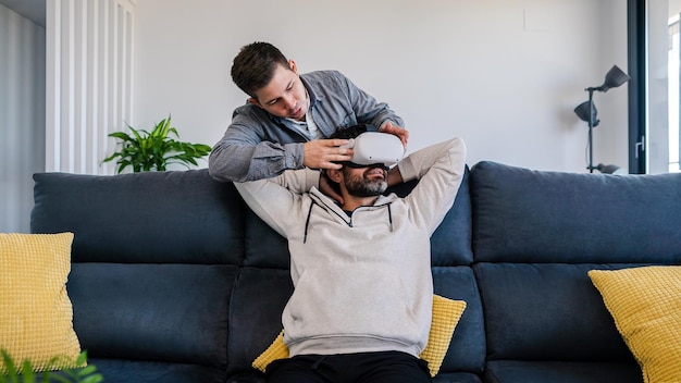 Blanke mannen genieten van een virtual reality-bril op de bank in een gezellige woonkamer thuis