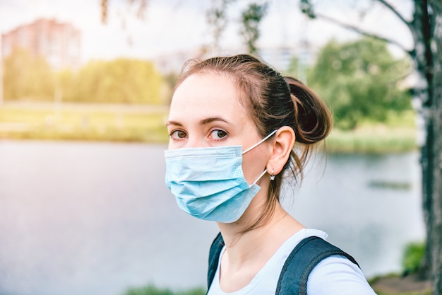 Blanke meisje loopt in de zomer door de stad in een masker