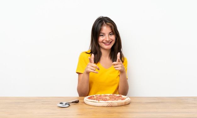 Blanke meisje met een pizza wijst vinger naar je