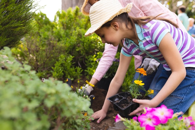 Blanke moeder en dochter brengen samen tijd door in de tuin aan het planten. Familie tijd buiten doorbrengen, tuin, tuinieren, concept.