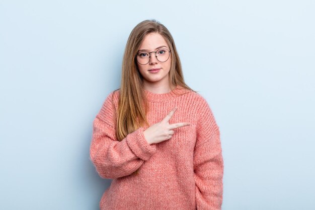 Blanke roodharige vrouw die zich gelukkig, positief en succesvol voelt, met de hand die een v-vorm over de borst maakt, overwinning of vrede toont