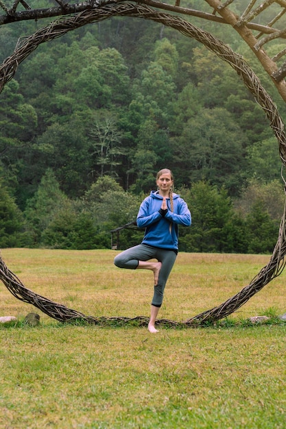 Blanke vrouw die alleen yoga beoefent in het bos. Welzijn.