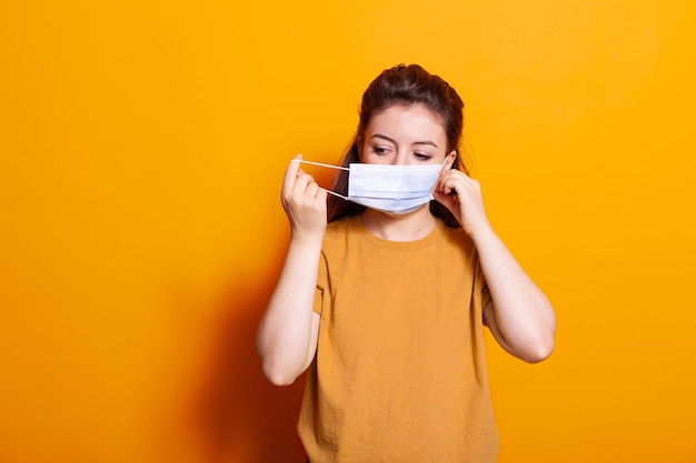 Blanke vrouw die een beschermend masker op het gezicht zet voor de camera. Positieve persoon die veiligheid en bescherming draagt voor preventie tegen coronavirus. Bescherming van volwassenen tijdens pandemie