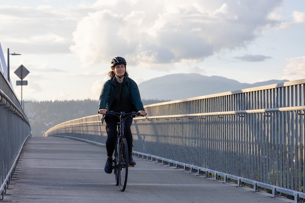 Blanke vrouw die op een fiets rijdt op een fietspad bij de brug van havenmannen