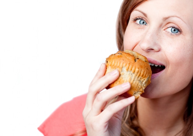 Blanke vrouw is het eten van een muffin