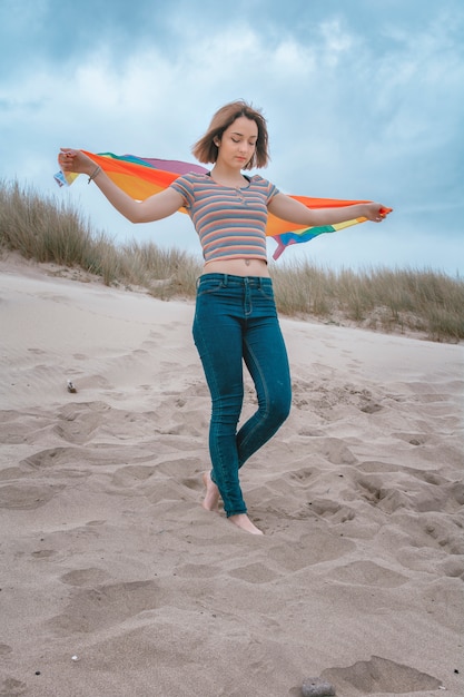 Blanke vrouw Lesbienne op het strand met regenboog Vlag Trots - Afbeelding