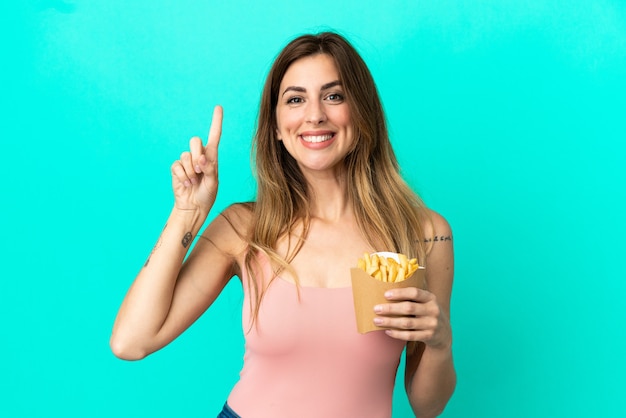 Blanke vrouw met gefrituurde chips geïsoleerd op een blauwe achtergrond die een geweldig idee benadrukt