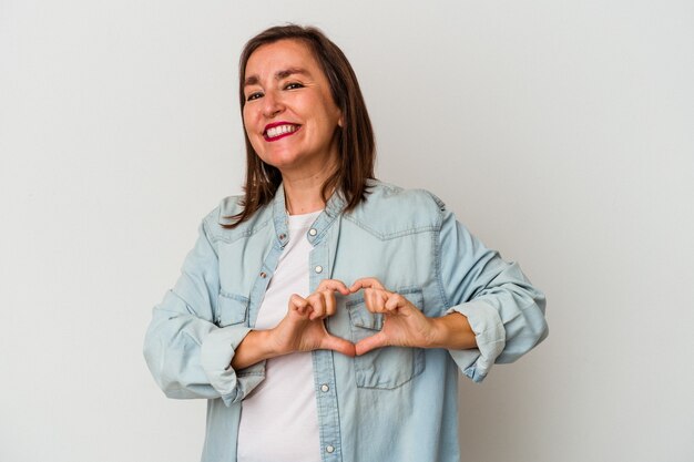 Blanke vrouw van middelbare leeftijd geïsoleerd op een witte achtergrond glimlachend en toont een hartvorm met handen.