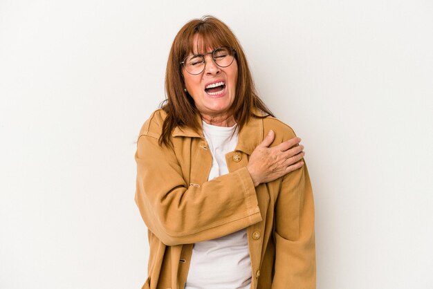 Blanke vrouw van middelbare leeftijd geïsoleerd op een witte achtergrond met pijn in de schouder.