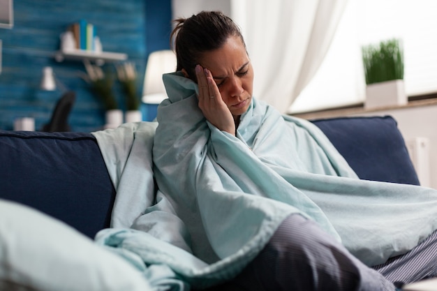 Foto blanke vrouw voelt zich thuis ziek met hoofdpijn