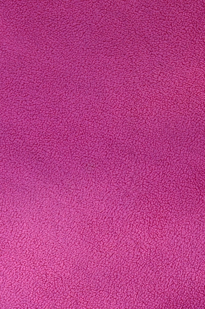 The blanket of furry pink fleece fabric. A background texture of light pink soft plush fleece material