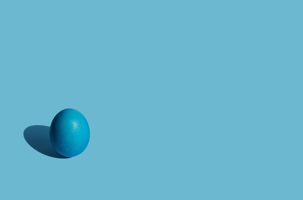 blauw ei met parelmoer op een blauwe achtergrond naar links