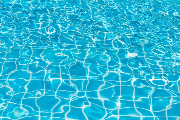 Blauw en helder wateroppervlak met zonreflectie in het zwembad