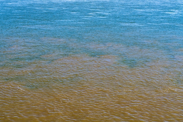 Foto blauw helder water van de rivier de ohio ontmoet bruine modderige mississippi