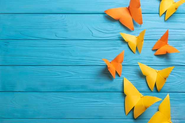 Blauw houten oppervlak met kleurrijke papieren origami vlinders met kopie ruimte voor uw tekst