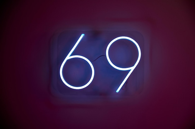 Blauw neonbord met nummer 69 trekt de aandacht van toeristen