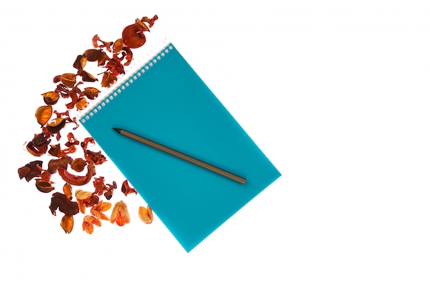 Blauw notitieboekje en potlood met oranje bloemen