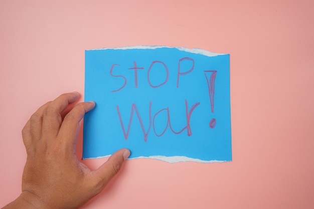 blauw papier met de tekst stop oorlog op een roze achtergrond