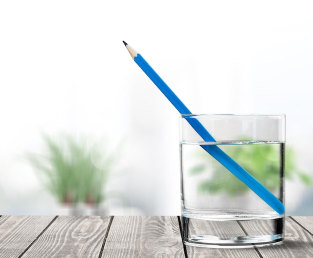 Blauw potlood, in een glas gevuld met water, uitleg van lichtbreking
