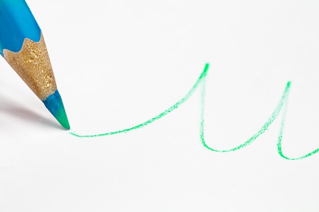 Blauw potlood tekent een golvende lijn in groen