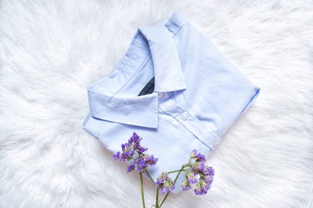 Blauw shirt op witte vacht, wilde bloemen Modieus concept