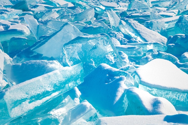 Blauw transparant ijs met sneeuw op het Baikal-meer in de winter De abstracte achtergrond van de ijstextuur