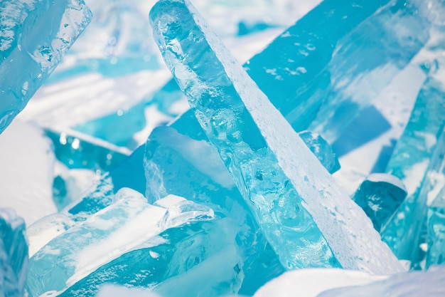 Blauw transparant ijs met sneeuw op het Baikalmeer in de winter