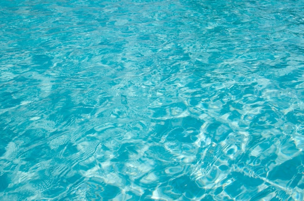 Blauw zwembadwater met zonreflecties