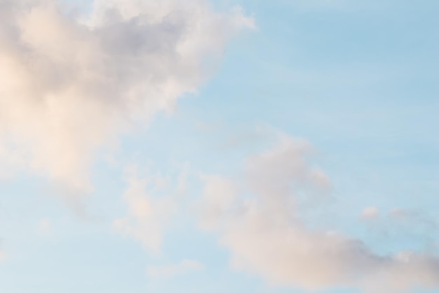 Blauwe achtergrond met bleke roze wolken bij zonsondergang