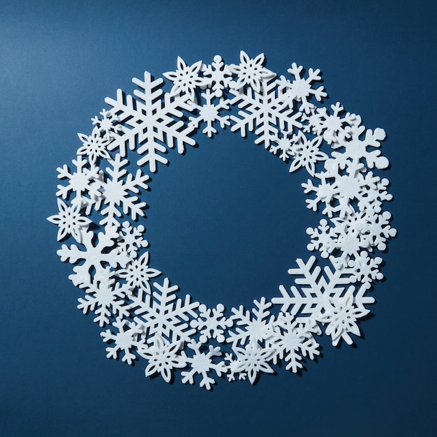 Foto blauwe achtergrond met ronde ruimte voor tekst en sneeuwvlokken. kan worden gebruikt als wenskaart voor kerstmis en nieuwjaar