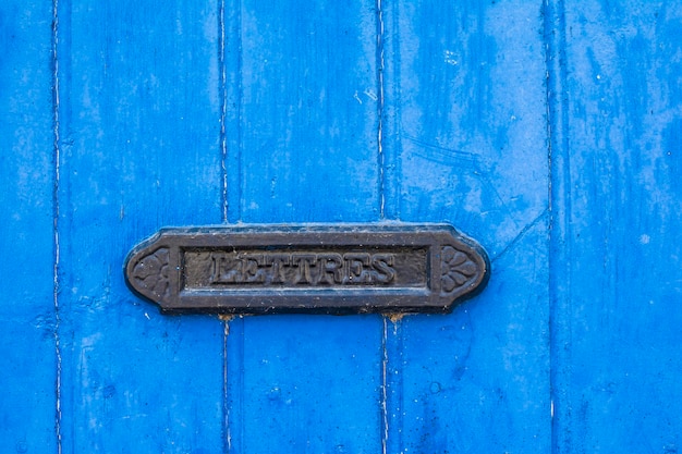 Blauwe armoedige deur met een vintage brievenbus