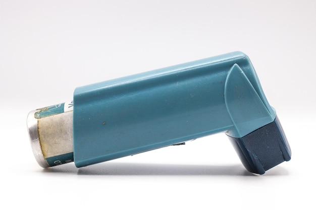 Blauwe astma-inhalator met blanco label geïsoleerd op witte achtergrond Farmaceutisch product wordt gebruikt om astma-aanvallen te behandelen of te voorkomen Gezondheid en medisch concept