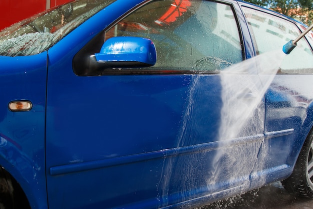 Blauwe auto in een autowasserette