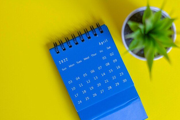 Blauwe bureaubladkalender voor april 2022 voor planning op een gele achtergrond