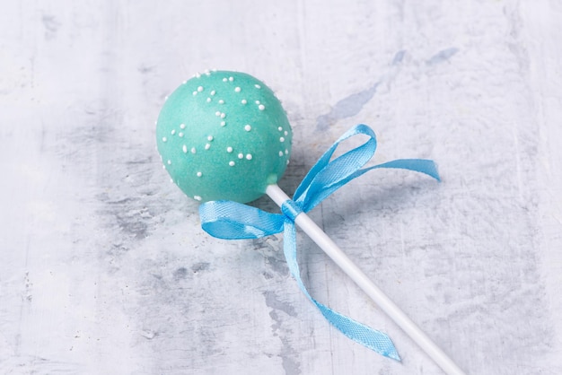 Blauwe cakepop op een gestructureerde achtergrond