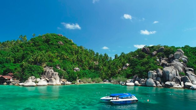 Blauwe catamaran lagune turquoise water palmbomen strand grote stenen Thailand
