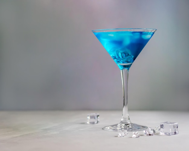 Blauwe cocktail in martini glas met ijsblokjes