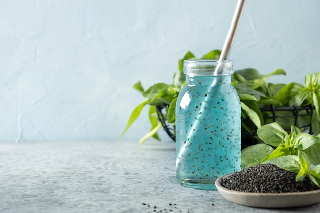 Blauwe cocktail met basilicumzaden en tropisch sap in glas op licht Close up