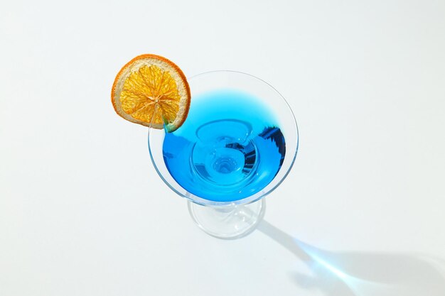 Blauwe cocktail met sinaasappel in glas op witte achtergrond