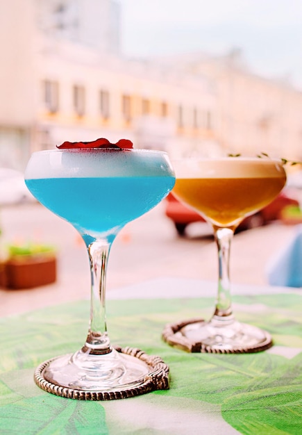 Blauwe curacao en beige cocktails staan buiten op tafel