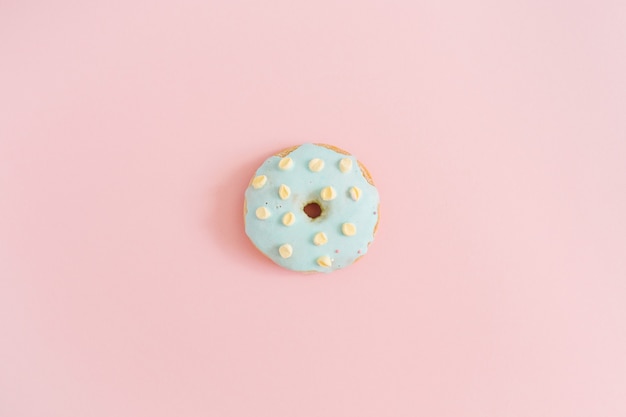 Blauwe donut op pastelroze achtergrond